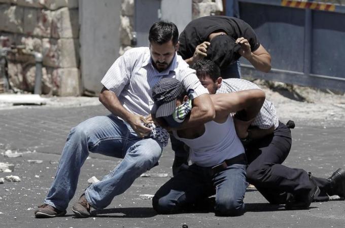 Israeli policemen arrest a Palestinian during clashes following Friday prayers in East Jerusalem [AFP]